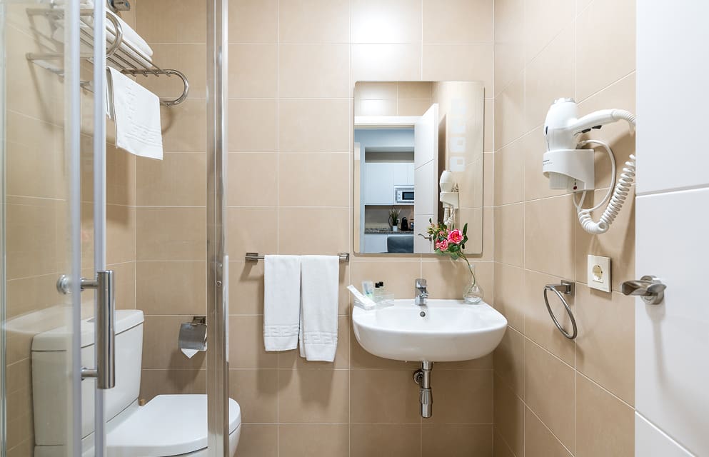 Cuarto de Baño | Lavabo Vista frontal del lavabo de uno de los apartamentos de Hoteles del Sur, con secador de pelo de pared.