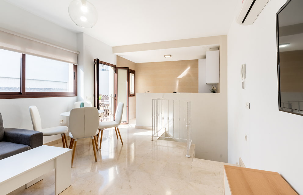 Sala de Estar | Vista General Vista general del salón-comedor de uno de los apartamentos, con salida a la terraza y cocina abierta