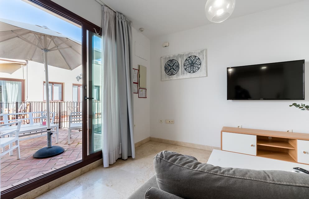 Apartamento con Terraza en Sevilla Salón-comedor con salida a una amplia terraza,con una gran sombrilla y mobiliario de exterior